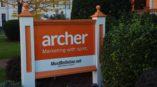Orange and white archer marketing outdoor sign