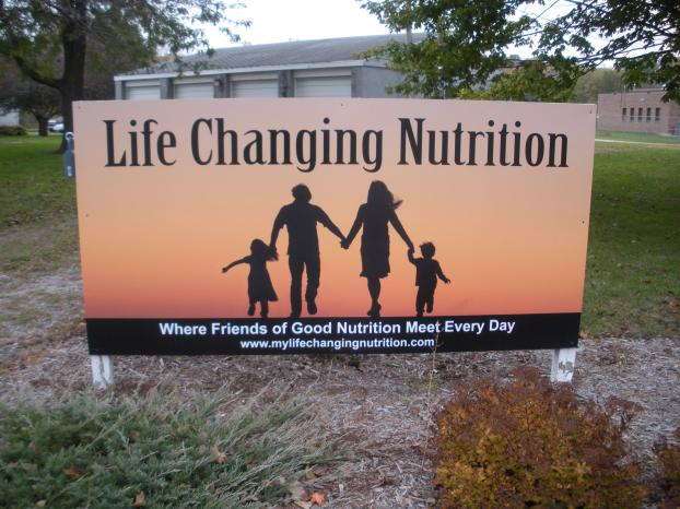 Life changing nutrition outdoor signage with family silhouette holding hands