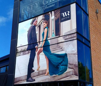 City Grill East Avenue window signage with woman and man posing