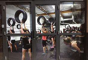 Window graphics of an exercise class where woman are lifting tires.