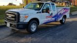 A pickup truck with a custom designed vehicle wrap for a garage door company.