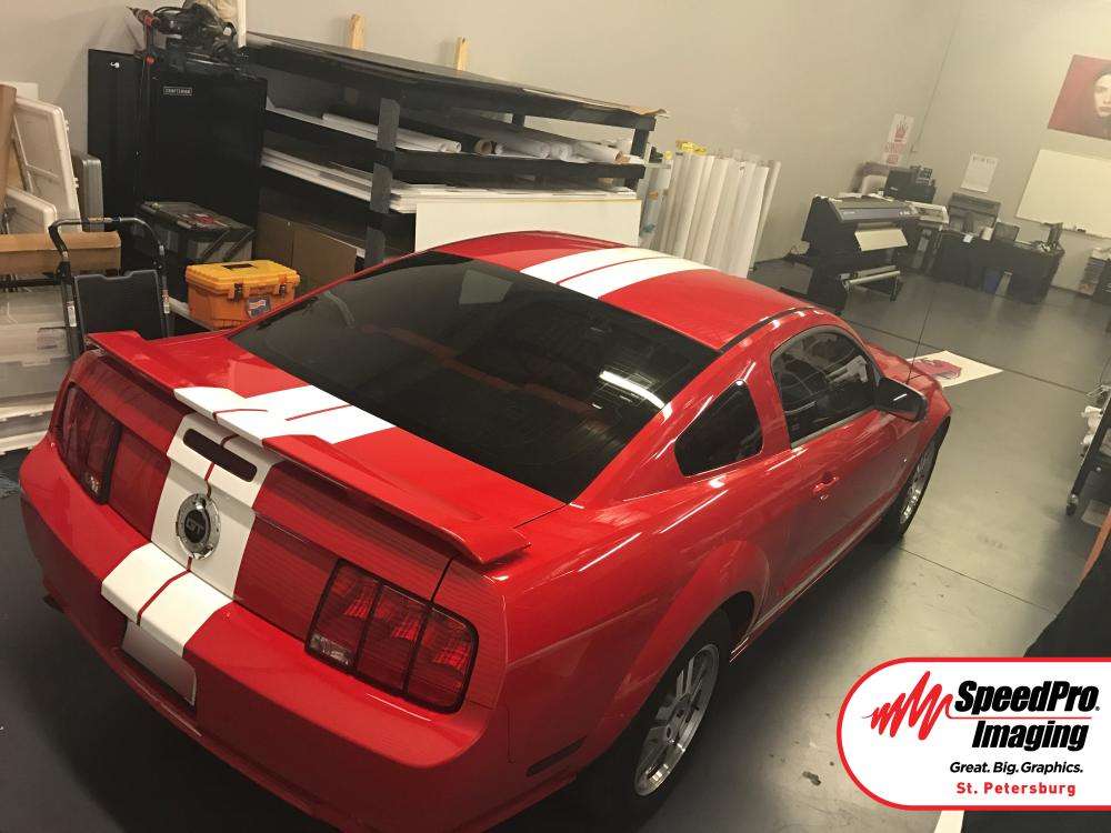 white vehicle decal stripe across red mustang