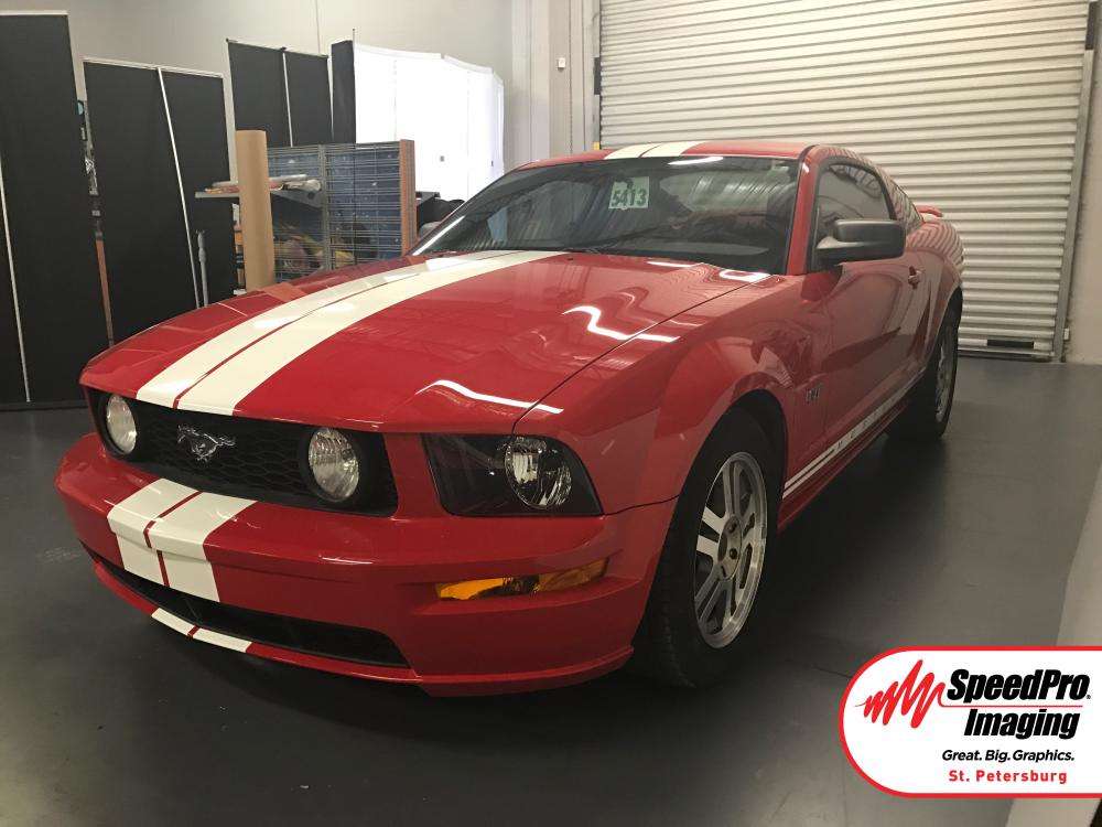 red ford mustang with white stripe across the car