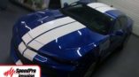 two white stripes on the front of a blue chevy camaro