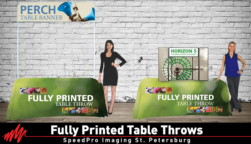 two women standing in front of fully printed table throws