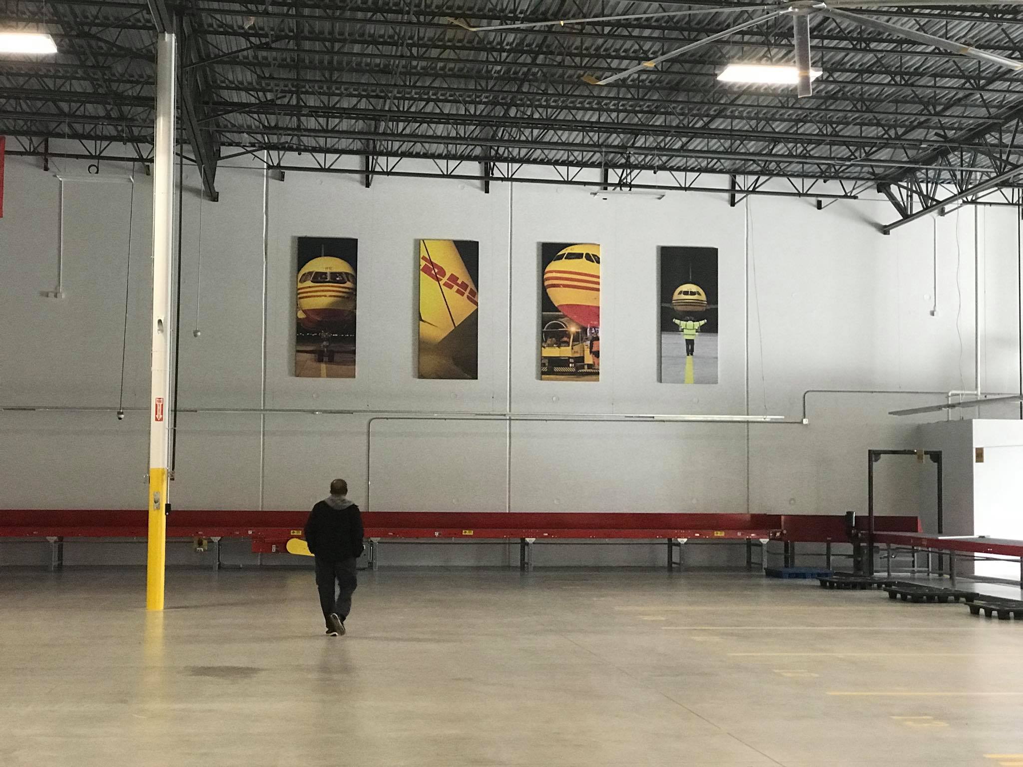 inside large warehouse with 4 canvas banners hanging on the wall