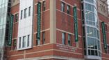 Large banners for Binghamton University hanging on the side of a brick building.