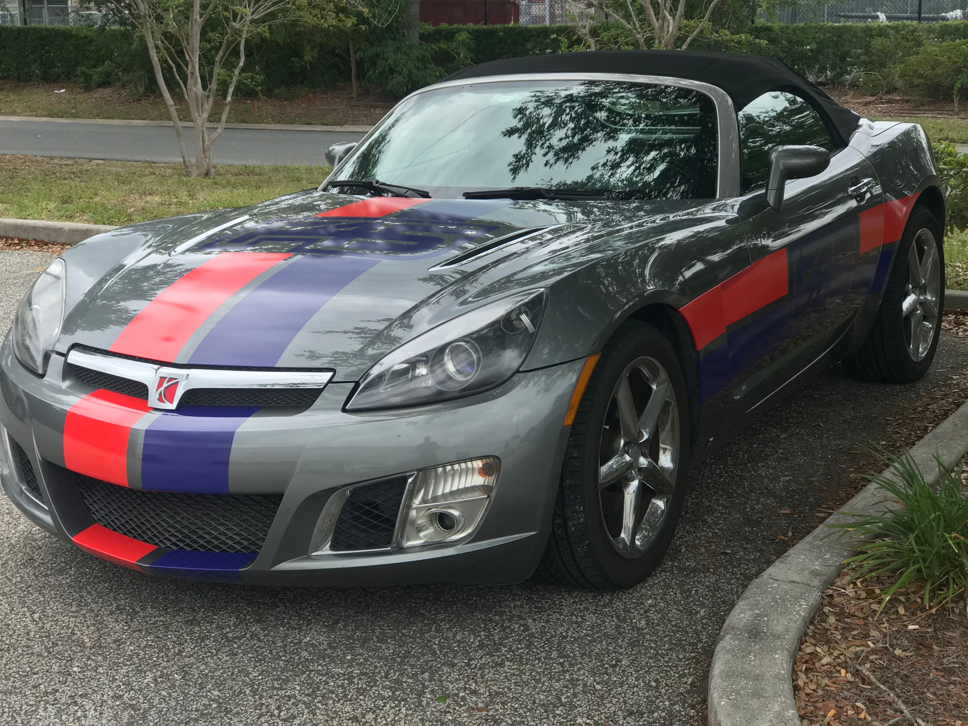 gray convertible with red and blue stripes