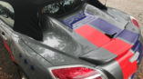 back of gray convertible with red and blue stripes