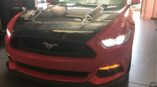 black and red mustang with front lights on