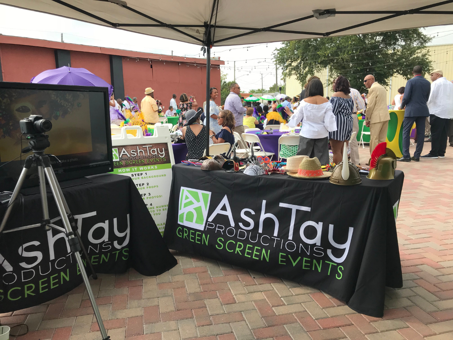 people at outdoor event with a table cover booth for AshTay Productions Green Screen Events