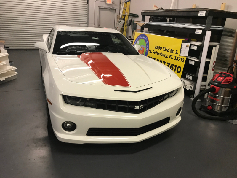 white camaro with 1 red stripe on hood of car