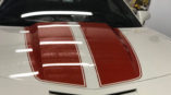white camaro with 2 red stripes on hood of car