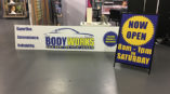 banner and a frame sign for The Body Works Auto Body and Paint Experts
