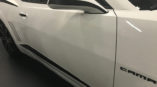 side mirror of white chevy camaro with black stripe
