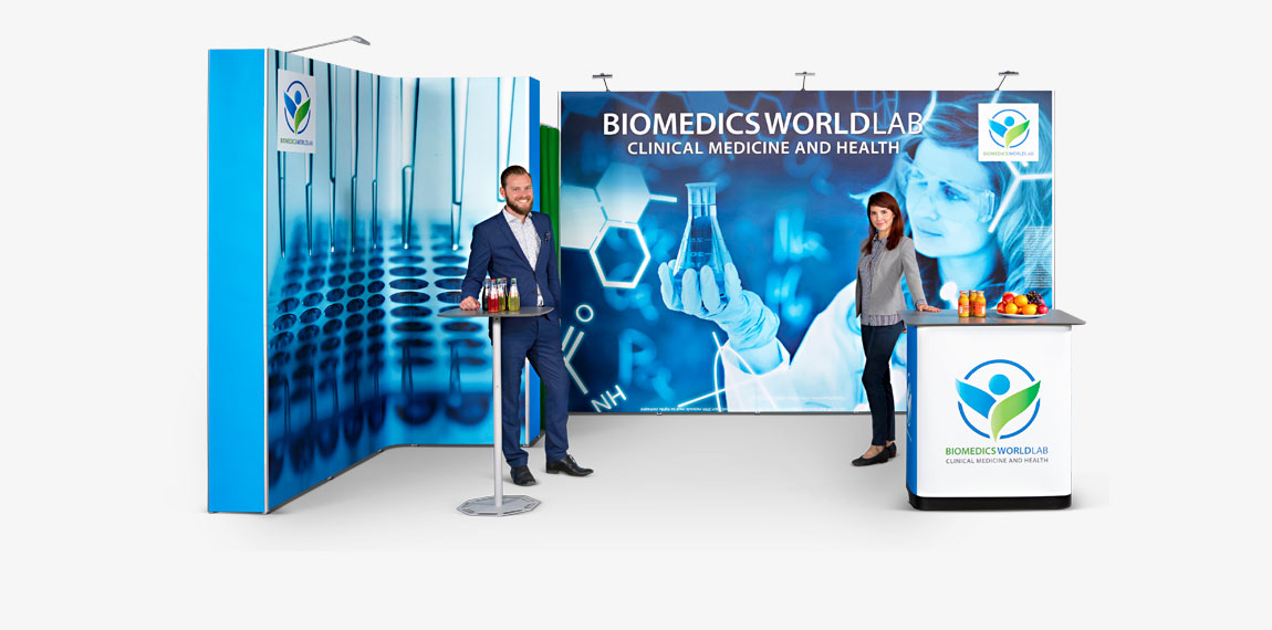man and woman standing in front of BioMedics World Lab trade show display