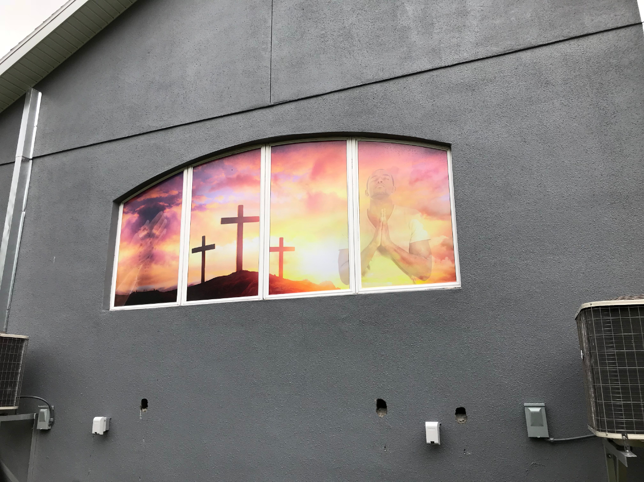 window graphic of 3 crosses and man with praying hands