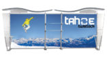 A display stand with an image of a snowboarder in mid air with snowcapped mountains in the background.