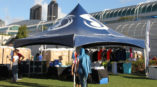 navy blue marquee tent with racks of clothing underneath