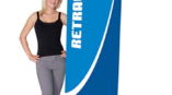Retractable banner stand with woman standing next to it