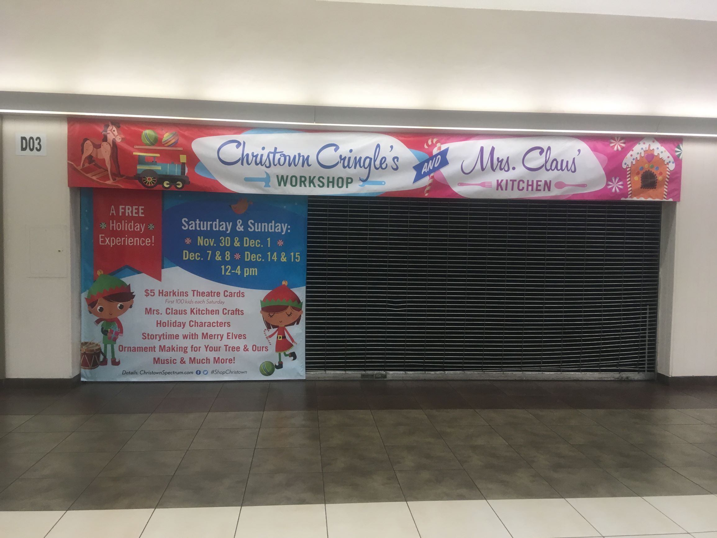 Christmas banners in a mall hung over a tenant space to create a Santa's Workshop space.