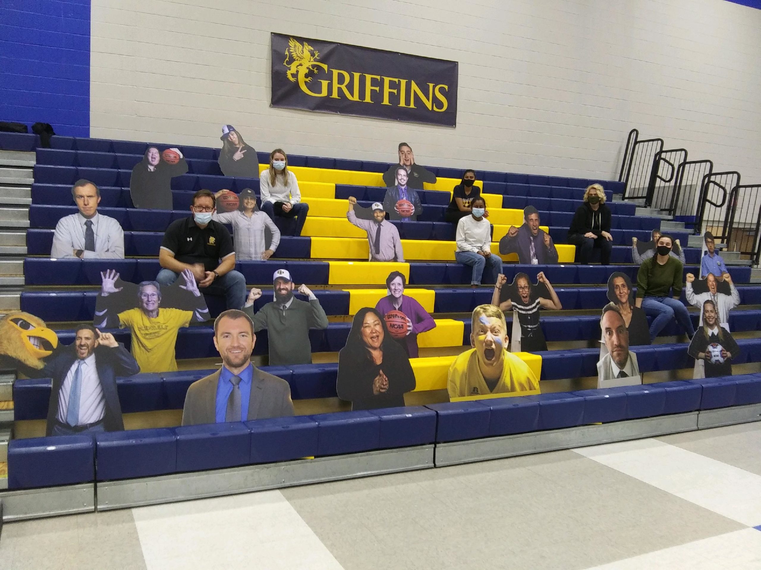 bleachers with socially distanced spectators that have cardboard cutouts of real people in between them