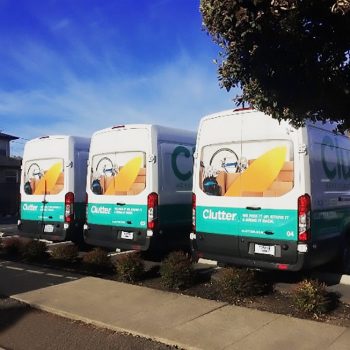 fleet of white vans with "Clutter" branding on them