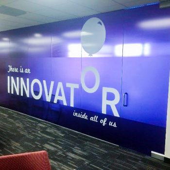purple mural on an interior wall and door that says "There is an Innovator inside all of us"