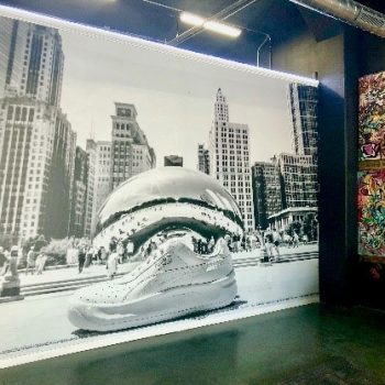 mural on interior wall of a store showing a white sneaker in front of Cloud Gate in Chicago