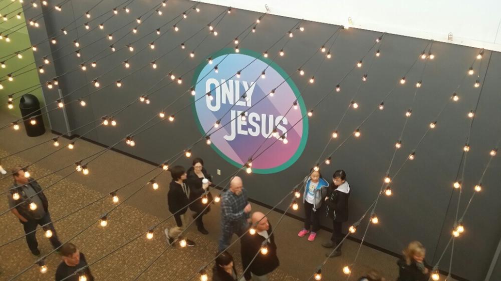 Only Jesus wall mural with people walking by