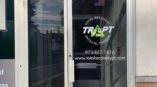 Glass door outside of building with a green triangle that says “Trapt” with “Total Recovery Physical Therapy” circling it.