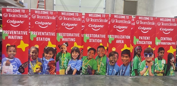 Colorful retractable banners for TeamSmile and Colgate at a children’s dental event, highlighting stations such as Preventative Waiting, Restorative Waiting, Sterilization Area, Patient Education, and Central Distribution.