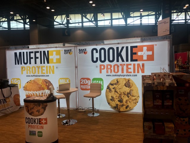 Advertising display banners of Bake City cookies and muffins at desert trade show