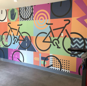 Colorful bicycle mural with tires and wheels on a vibrant wall