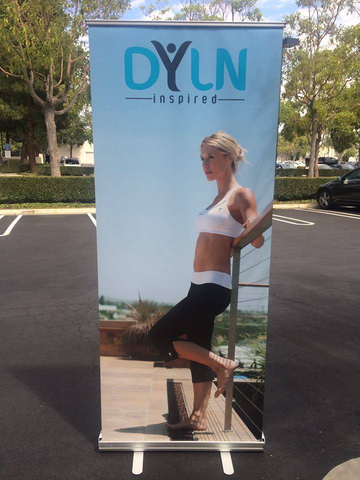 A banner of a blonde woman in work out clothes leaning against a banister with Dyln Inspired written above her head.