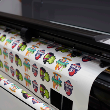 Sheets of window graphics coming out of a printer 
