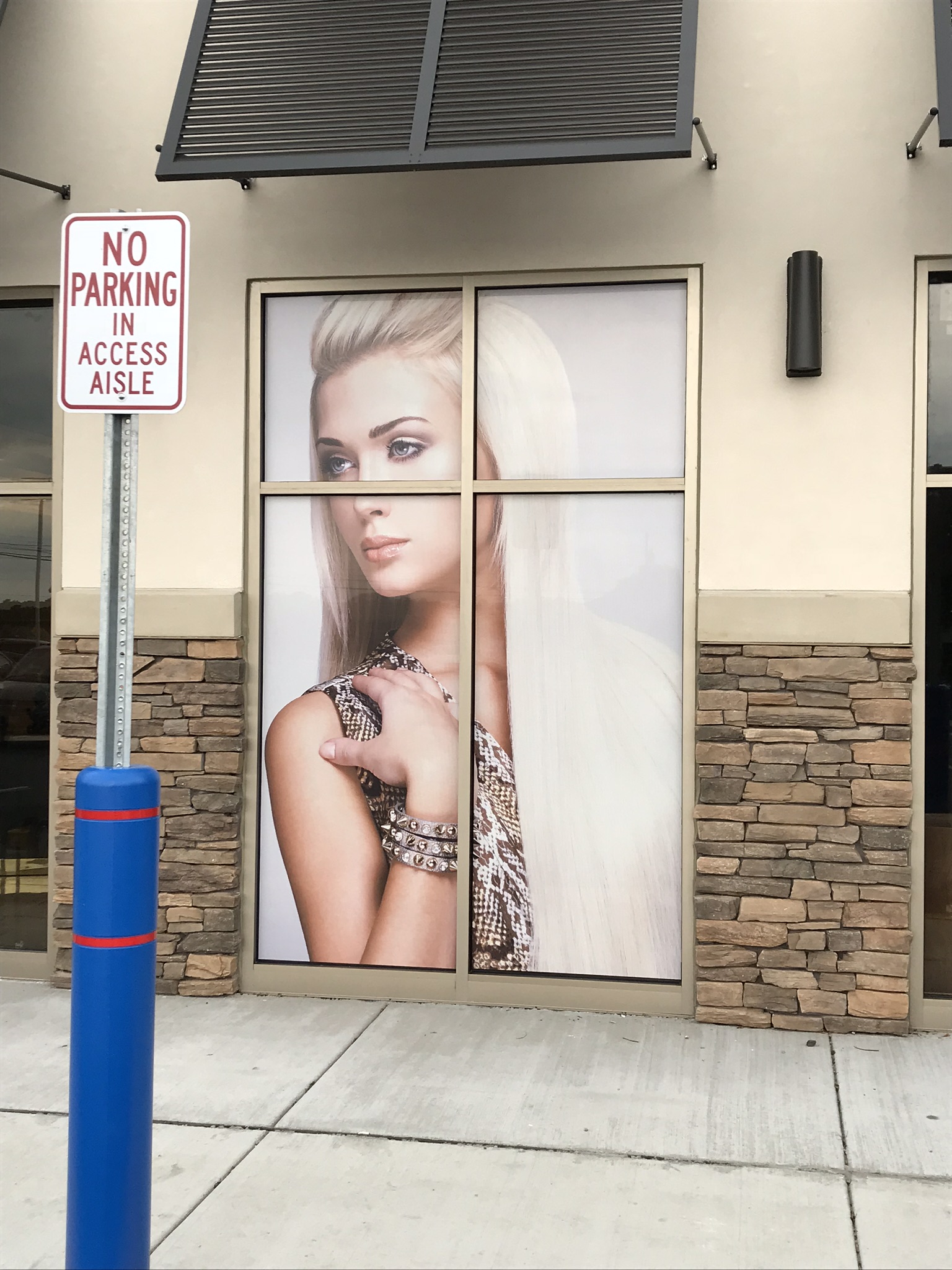 Curb graphic on a window featuring a woman with long blonde hair 