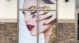 Window graphic of a woman showing off her jewelry and makeup
