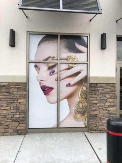 Window graphic of a woman showing off her jewelry and makeup