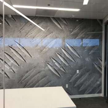 Wall mural of metal engravings in an office space created by SpeedPro 