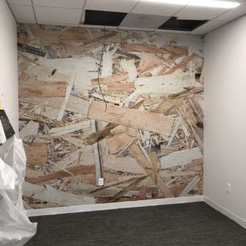 Wall mural of wood scraps in an empty office space created by SpeedPro 