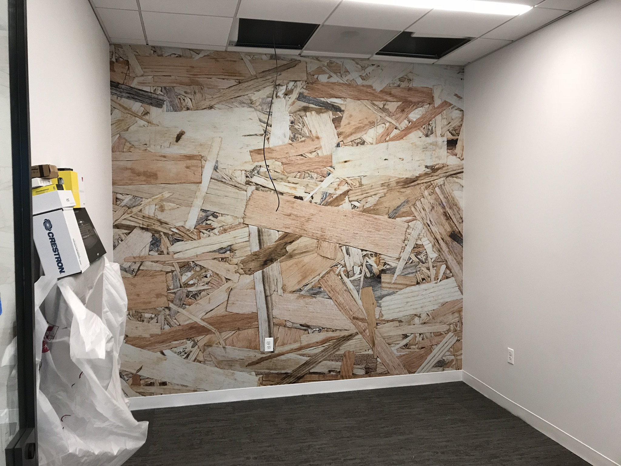 Wall mural of wood scraps in an empty office space created by SpeedPro 