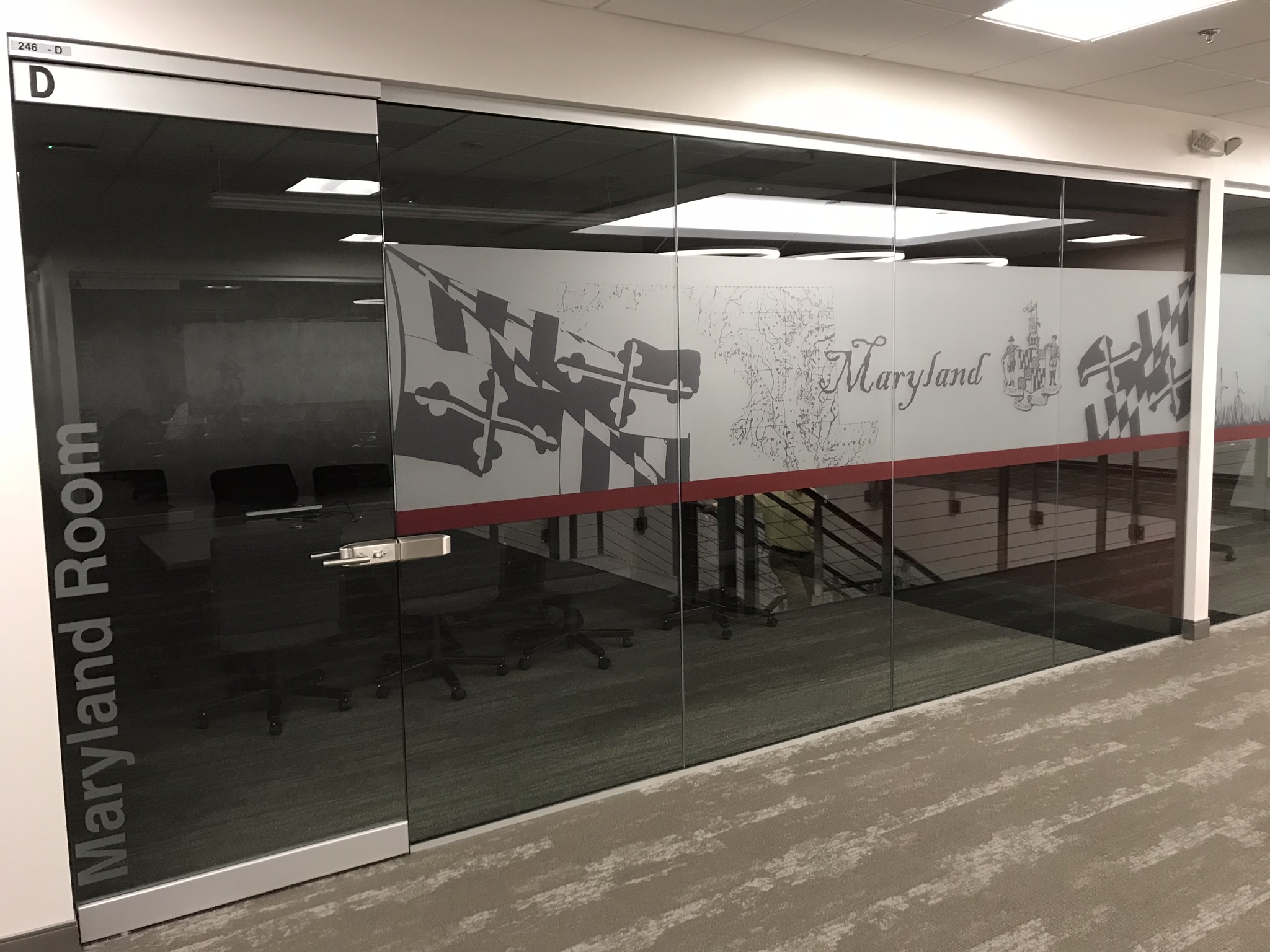 Indoor sign on glass windows with images of Maryland map and flag 