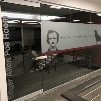 Indoor sign on glass windows with graphics of Edgar Allan Poe with handwriting and black bird 