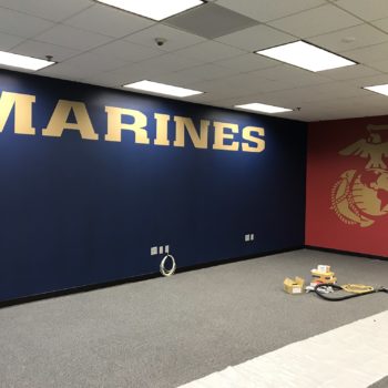 Wall decals for the Marines featuring their logo on blue and red walls 