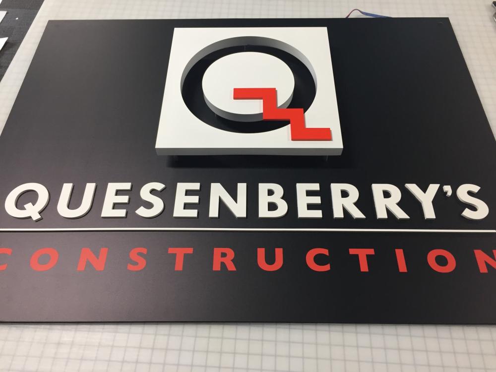 Quesenberry's Construction logo sign on wall