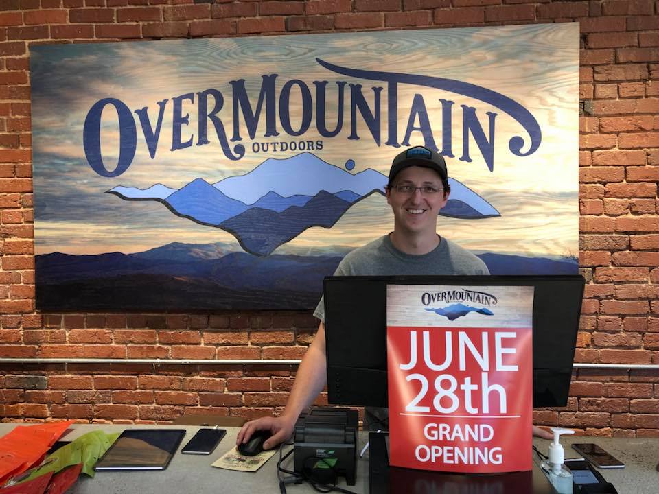 Over Moutain Outdoors mural sign hanging behind counter