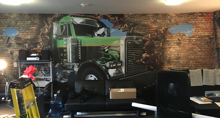 wall graphic of a truck breaking through a wall