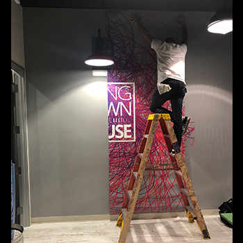 Person installing a wall graphic