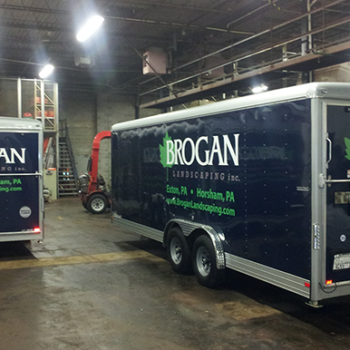 Two trailers with custom vehicle wraps for Brogan landscaping Inc.
